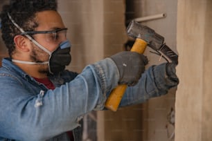 a man wearing a face mask and holding a hammer
