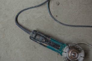 a corded electric tool laying on the ground
