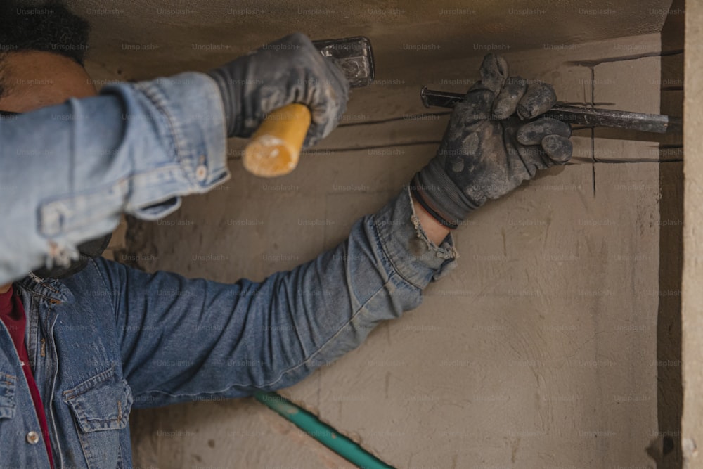 a man is working on a wall with a wrench