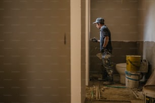 a man standing in a room with a paint roller
