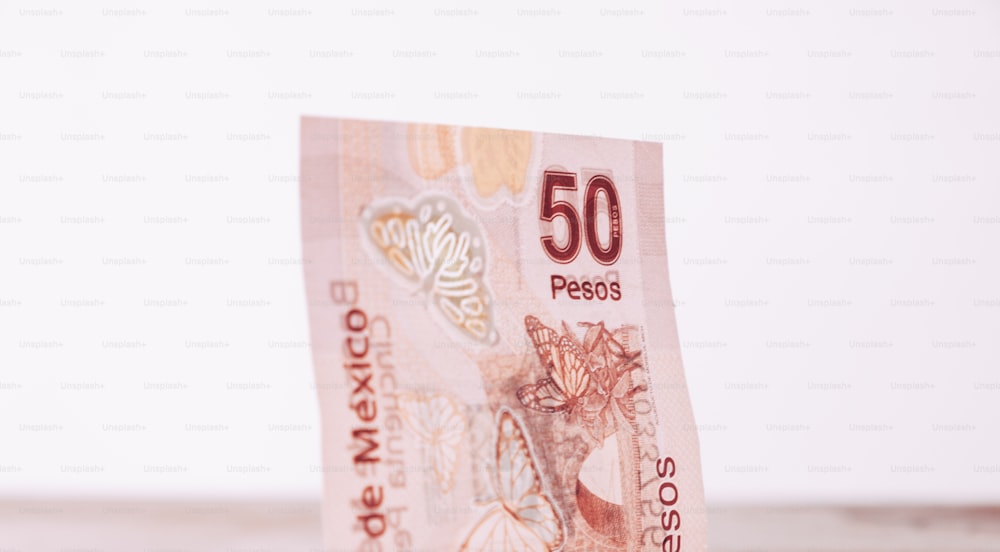 a 50 peso note sitting on top of a table