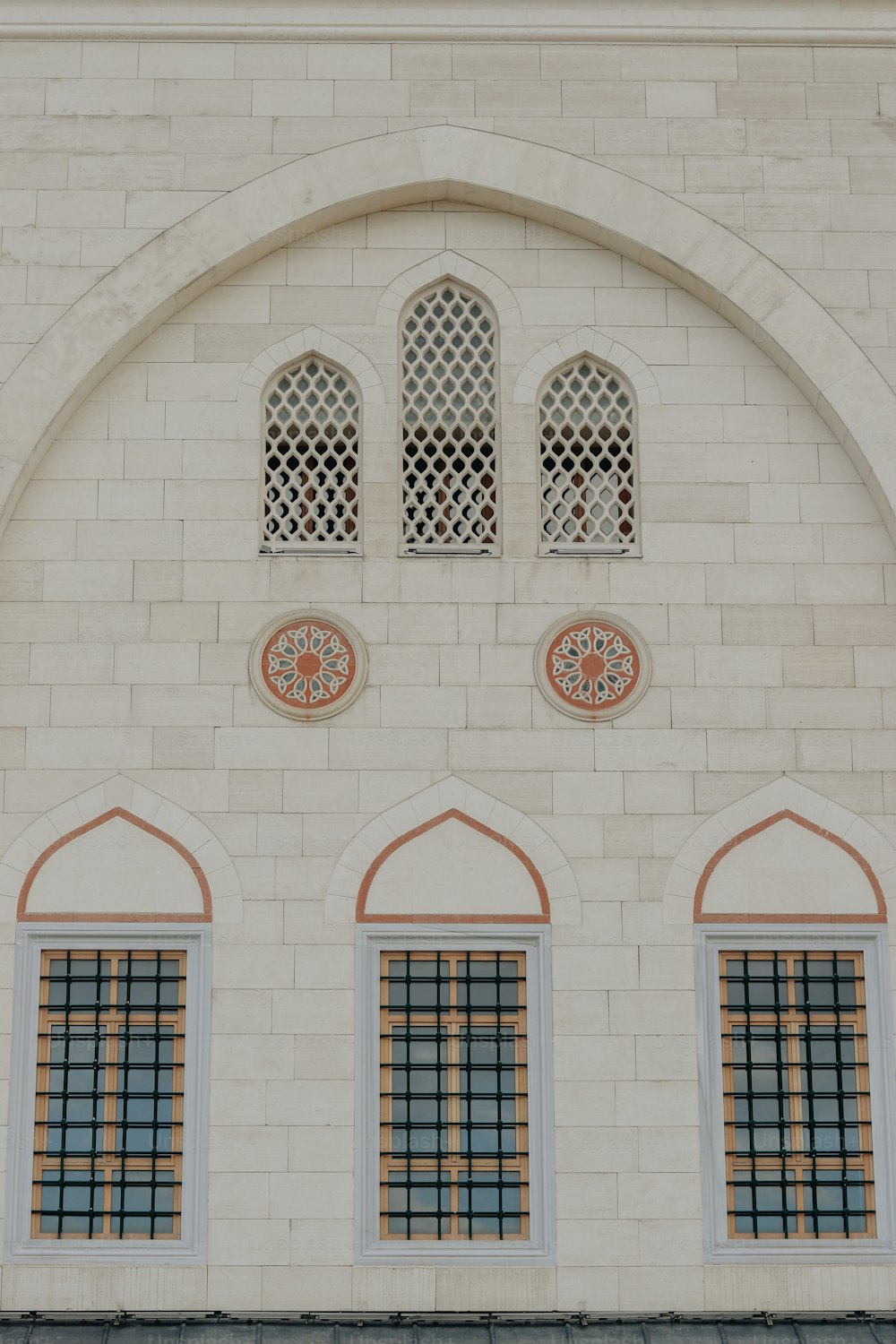 アーチ型の窓と時計のある白いレンガ造りの建物