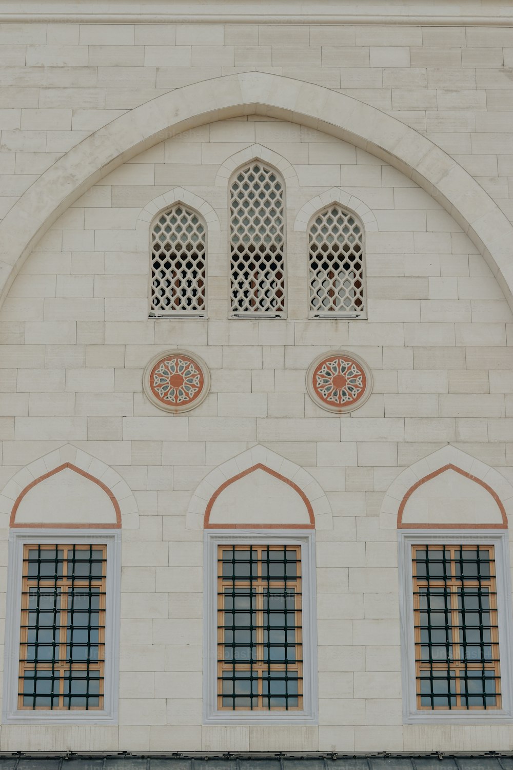 a white brick building with arched windows and a clock