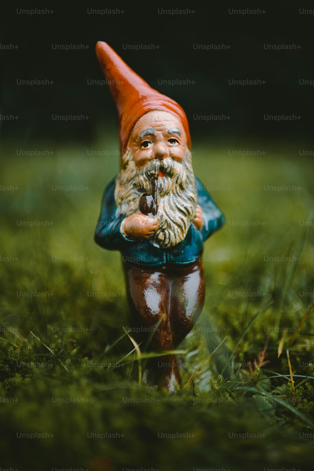 Une figurine de gnome assise dans l’herbe