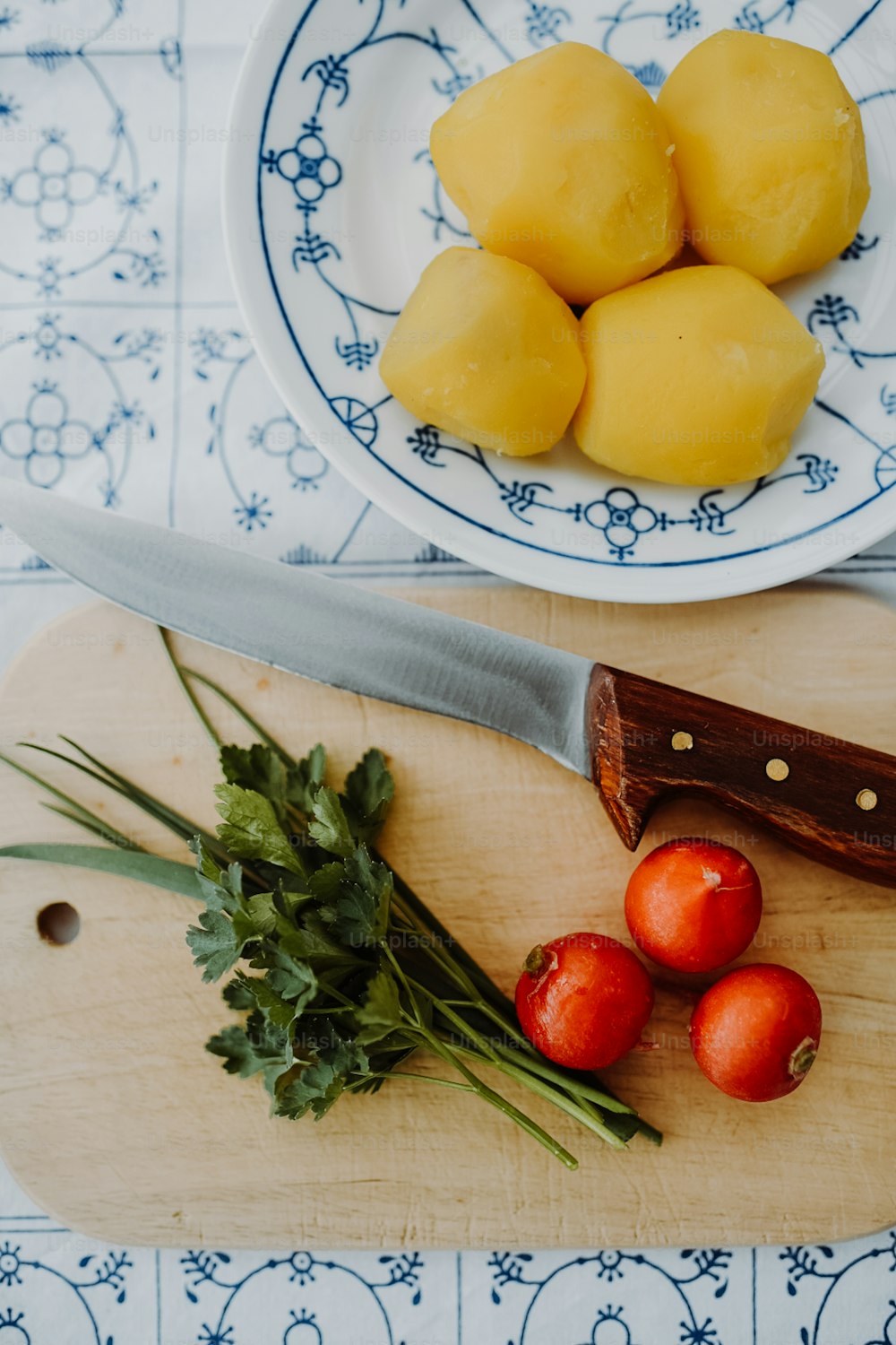uma tábua de corte com uma faca e alguns tomates sobre ela