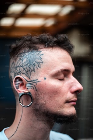 un homme avec un tatouage sur le visage et l’oreille