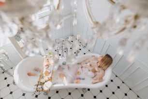 a woman laying in a bathtub filled with bubbles