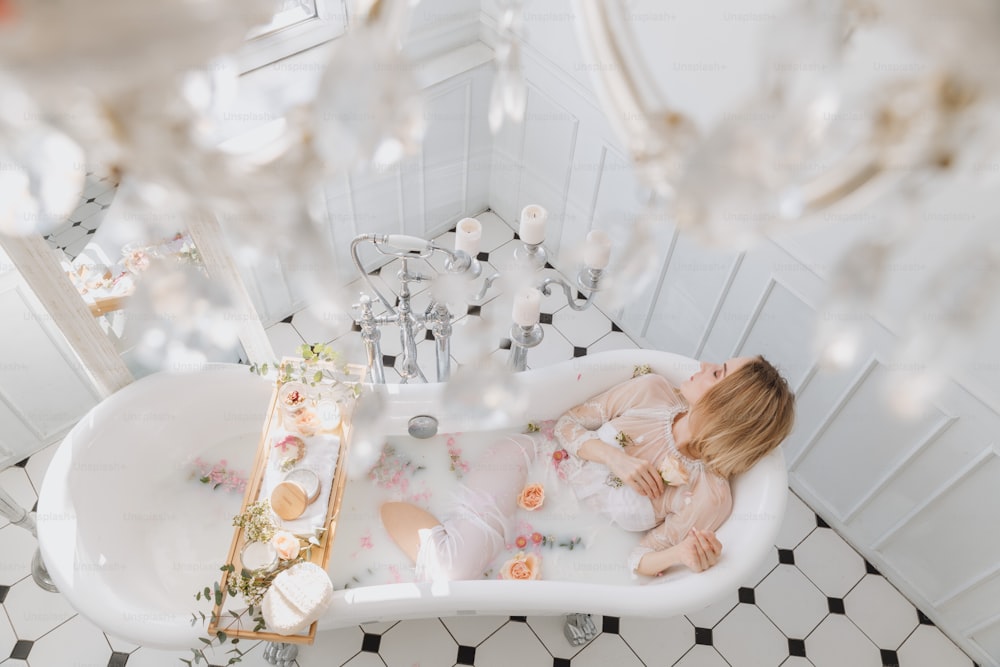 a woman laying in a bathtub in a bathroom