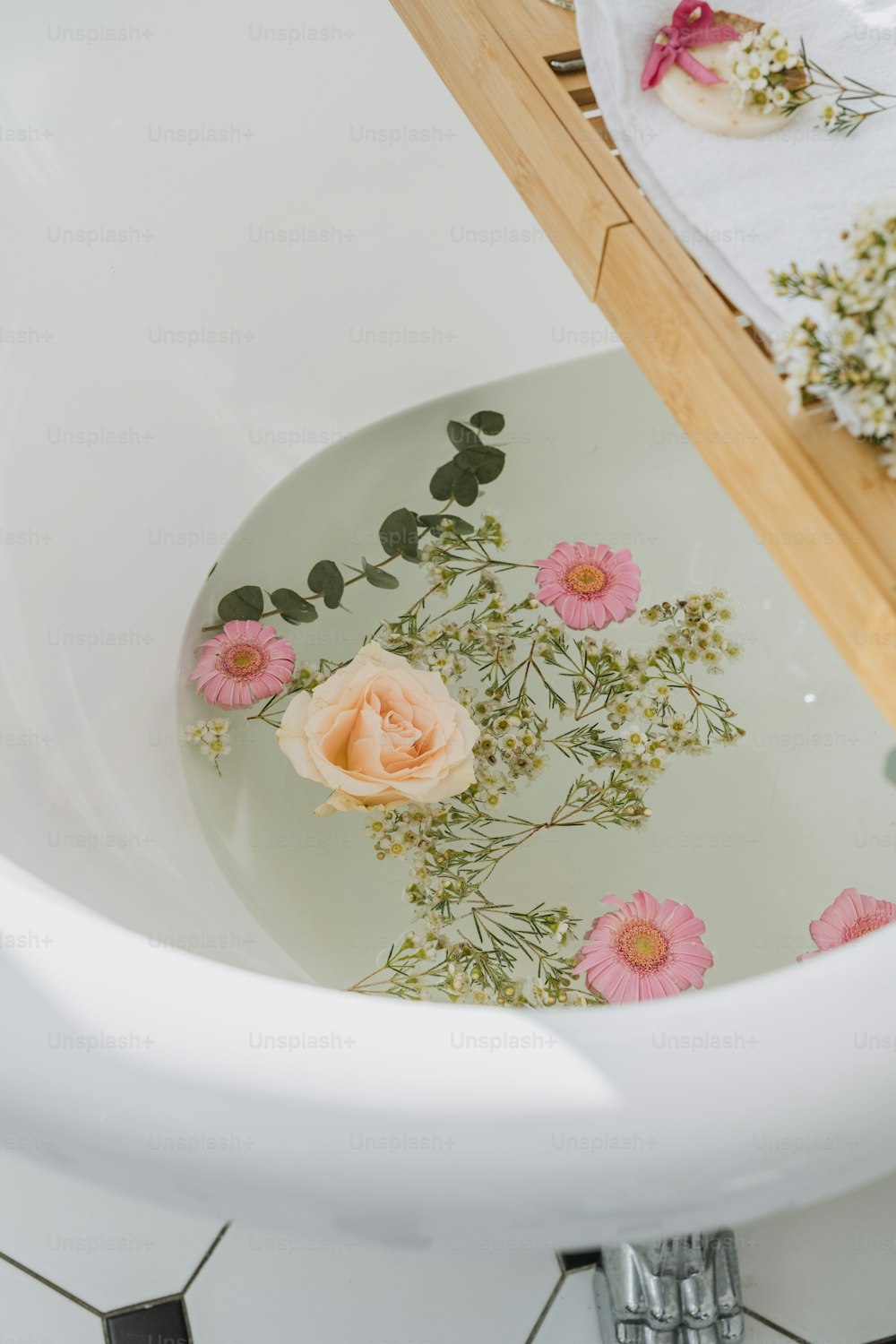 un évier blanc avec des fleurs roses dessus
