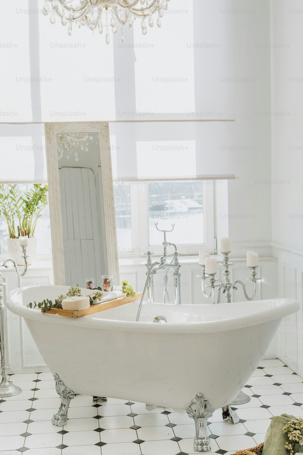 une baignoire blanche assise dans une salle de bain à côté d’une fenêtre
