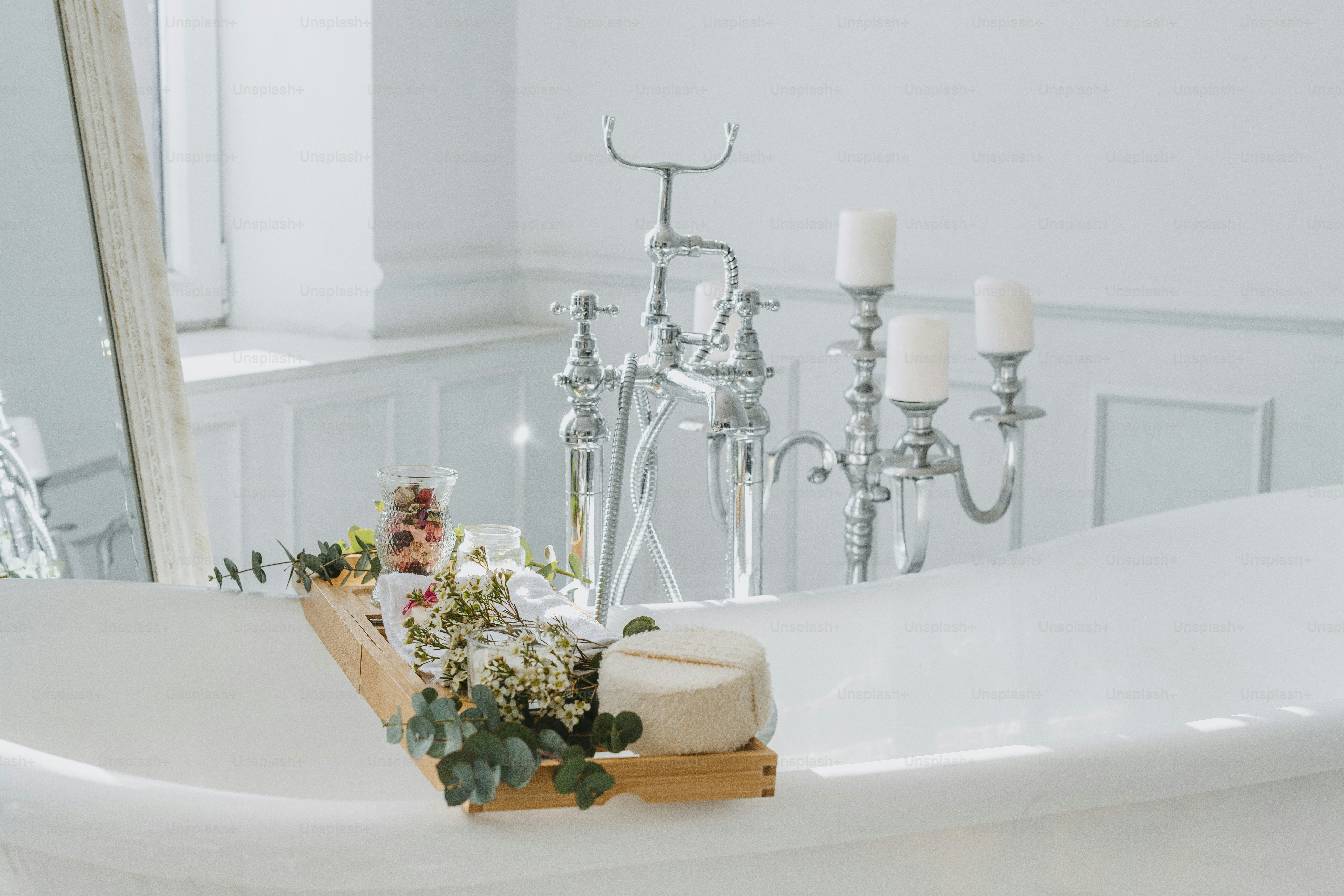 a bathtub with candles and flowers in it