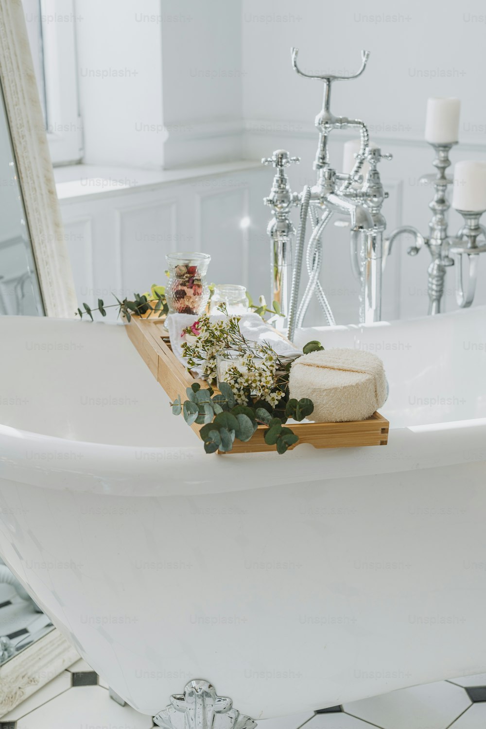 una vasca da bagno con fiori e candele su di esso