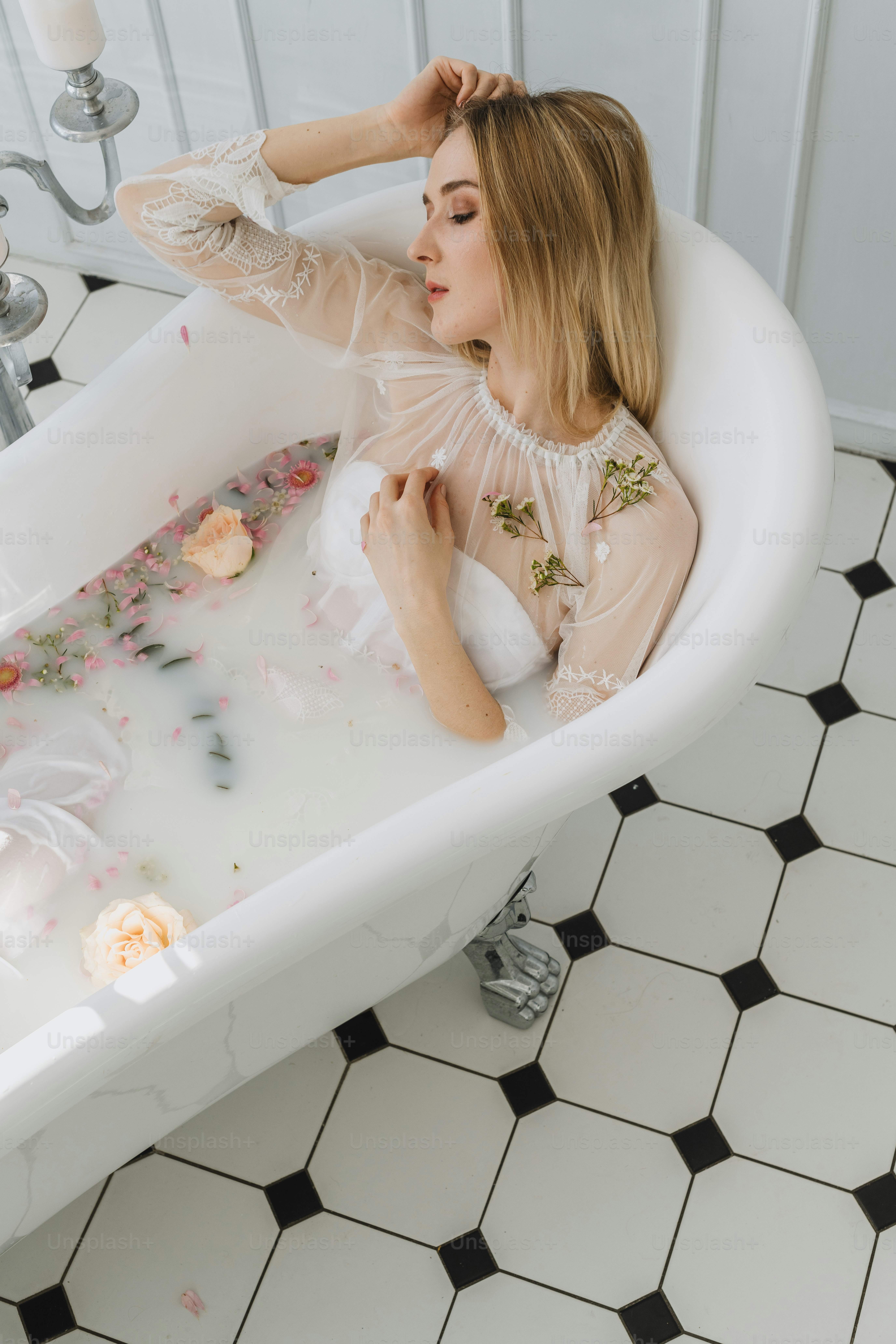 a woman sitting in a bathtub with flowers all over it