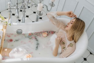 a woman sitting in a bathtub filled with flowers