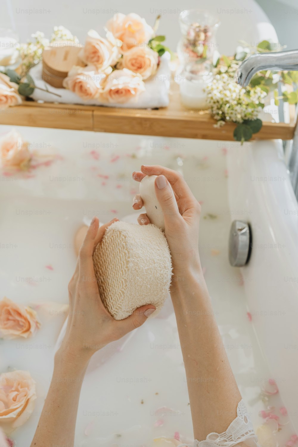 a woman is washing her hands in a bathtub