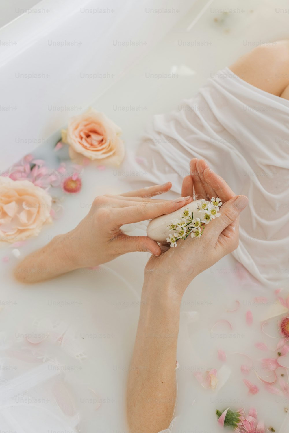 a woman laying in a bathtub with flowers on the floor