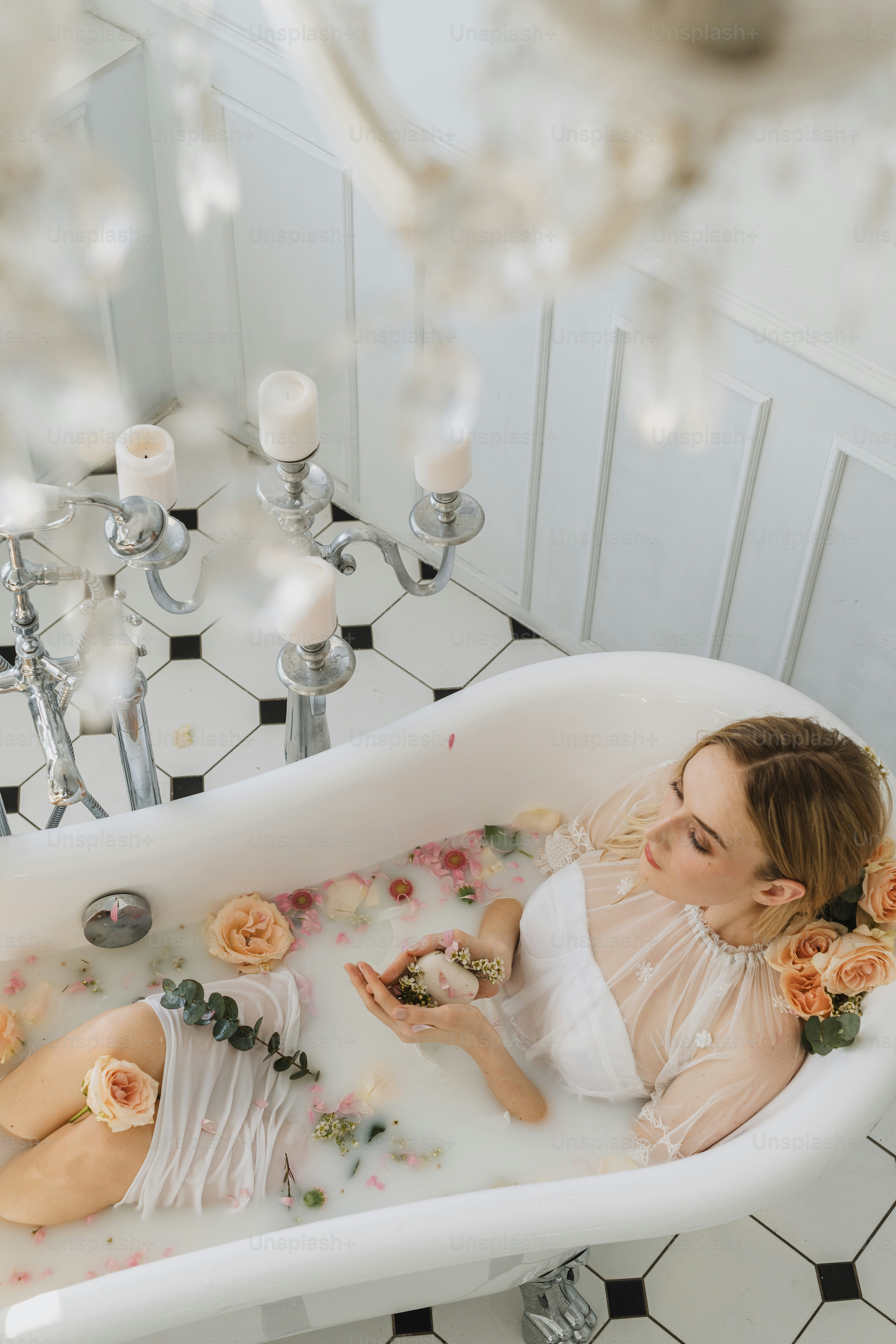 a woman sitting in a bathtub with flowers in it