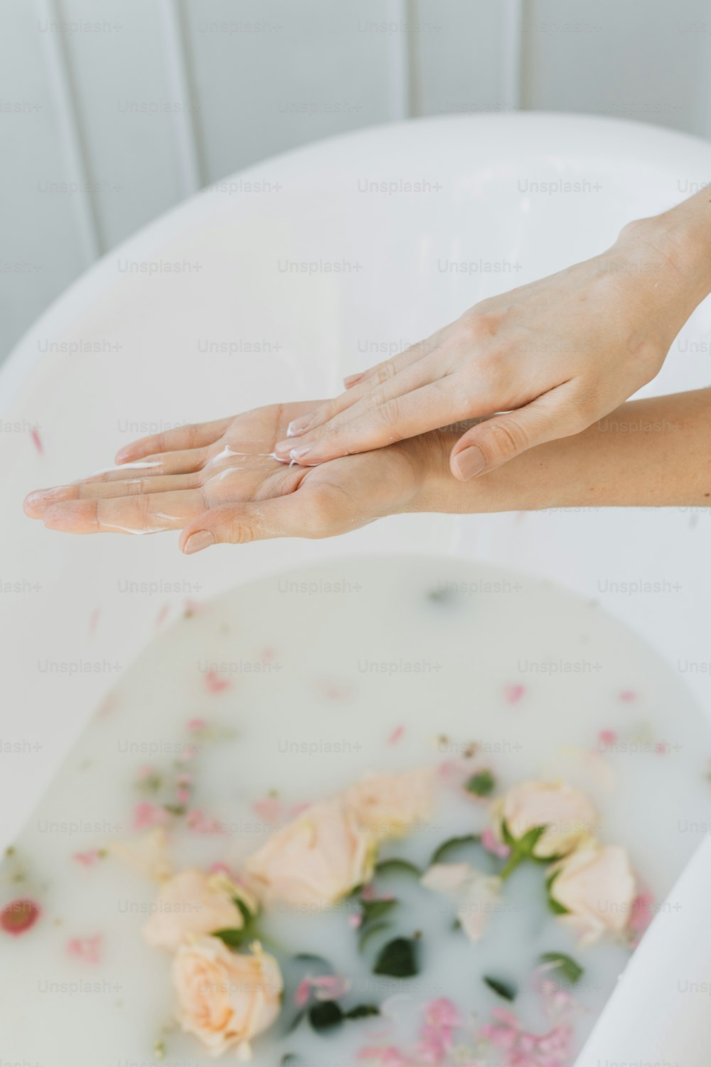 uma mulher lavando as mãos em uma banheira