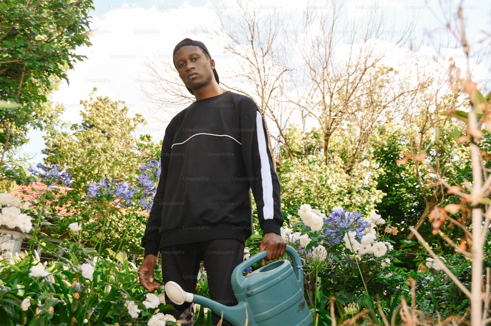 a man holding a watering can in a garden