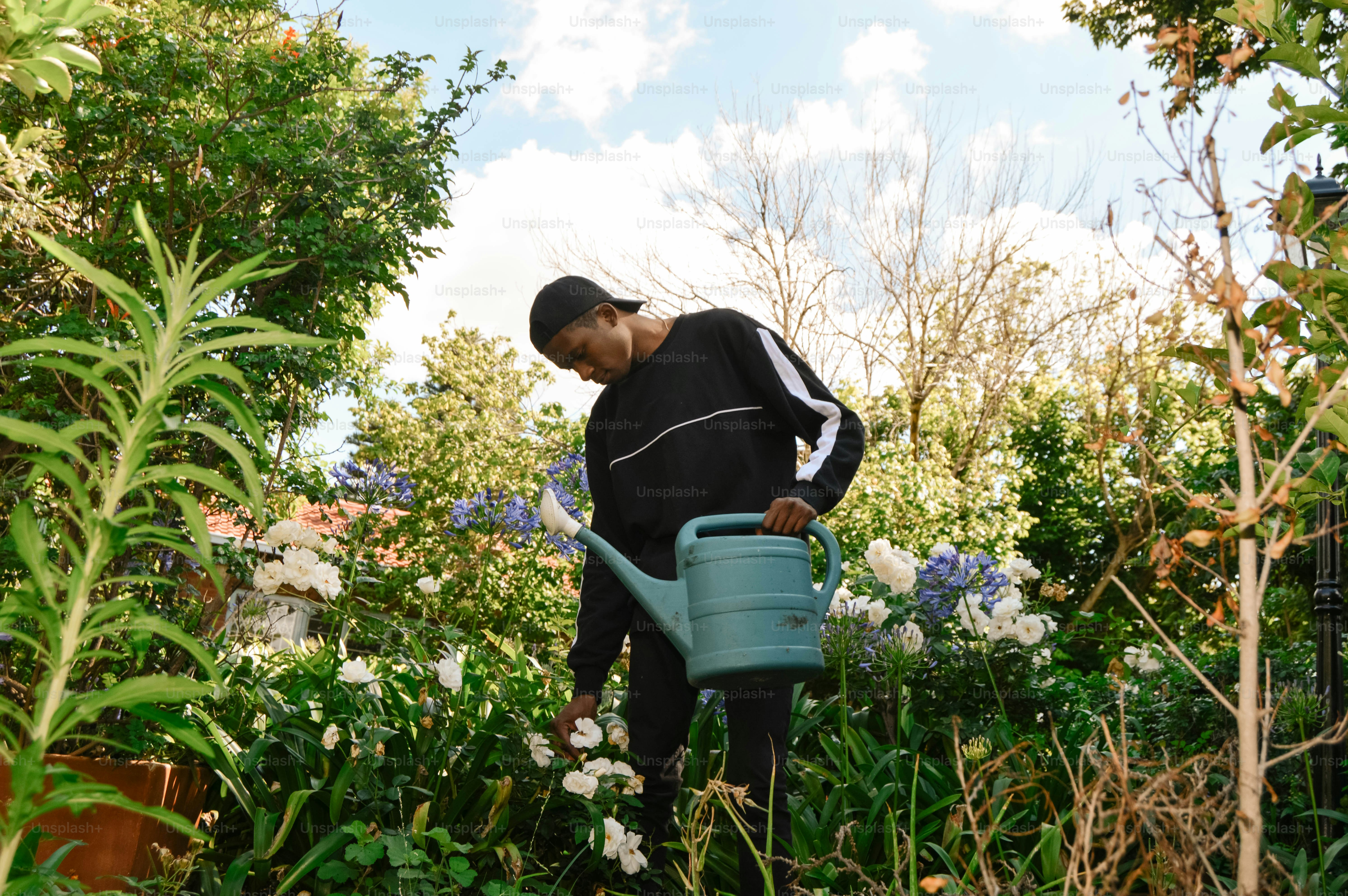 a man with a watering can in a garden