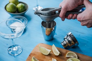a person using a juicer on a table with limes