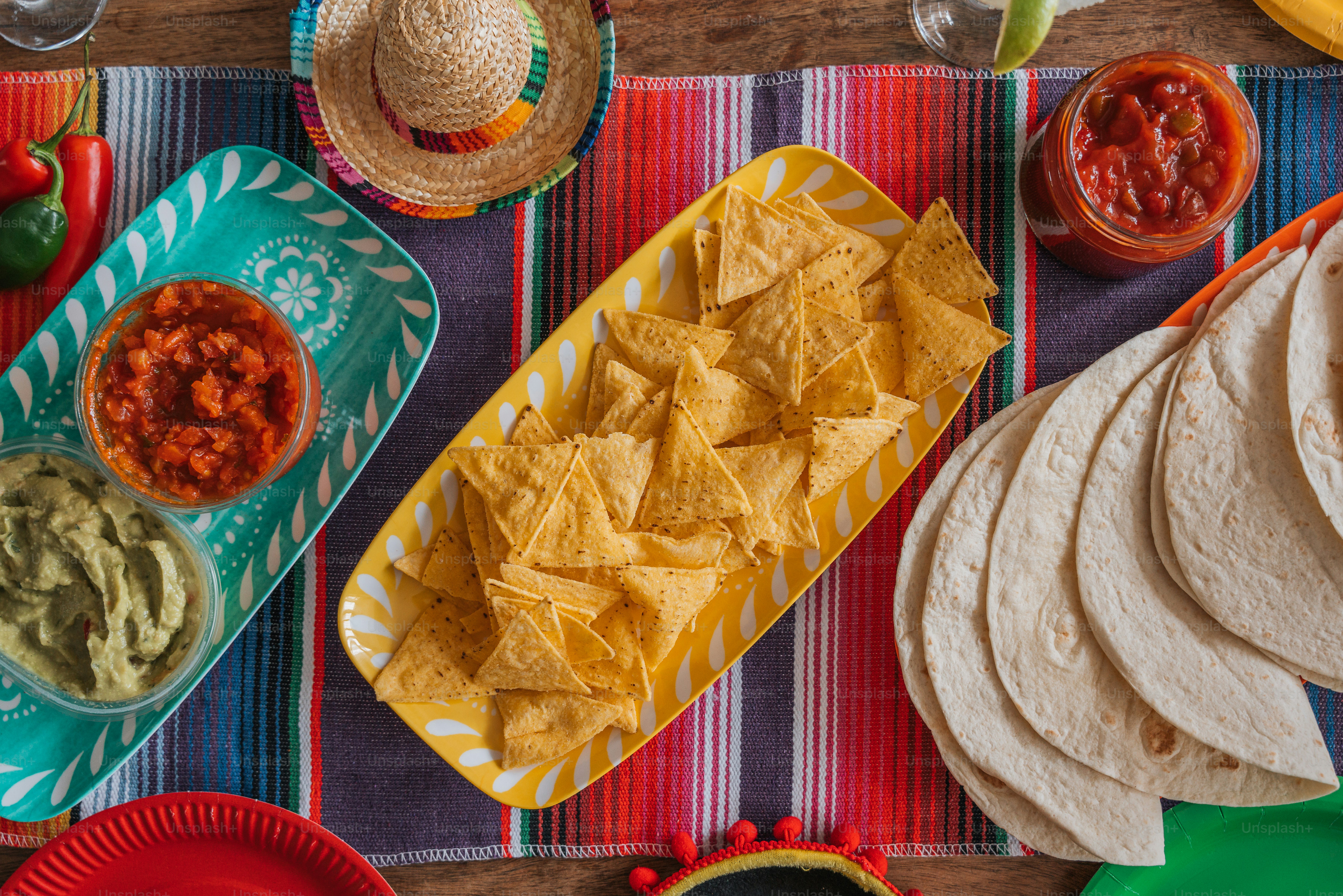 une table surmontée d’assiettes de nachos et de guacamole