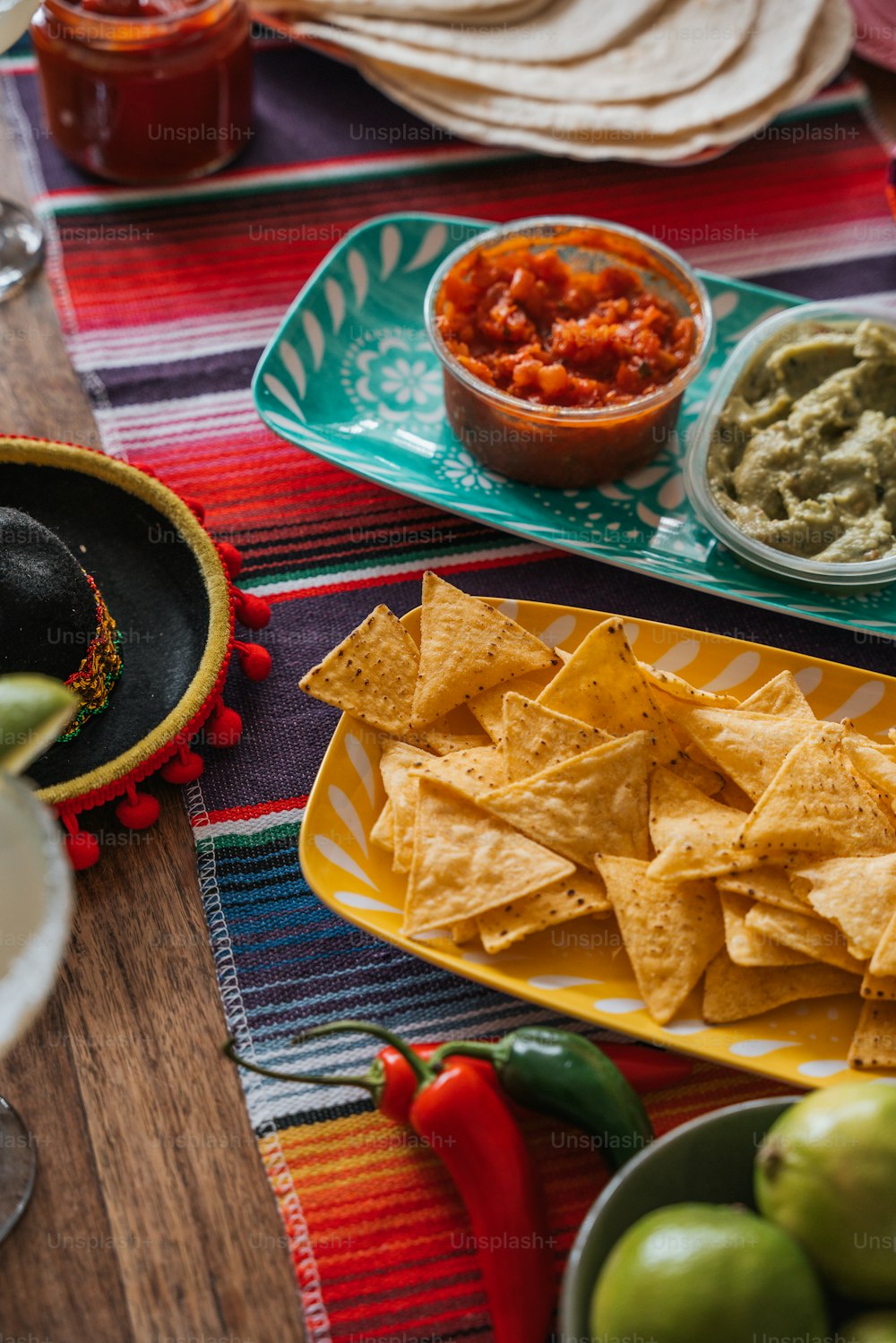 uma mesa coberta com pratos de nachos e guacamole