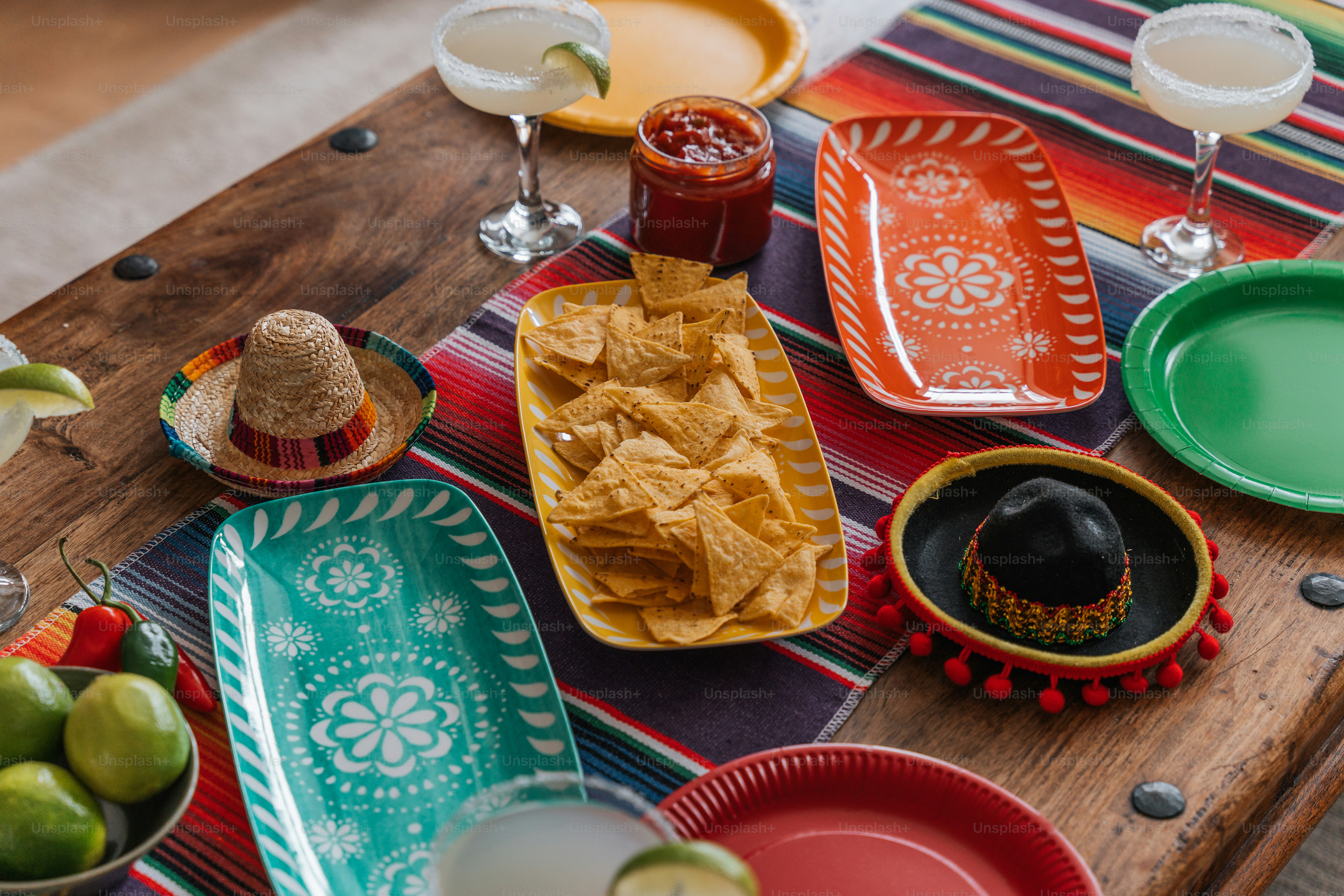 a wooden table topped with plates and bowls filled with food