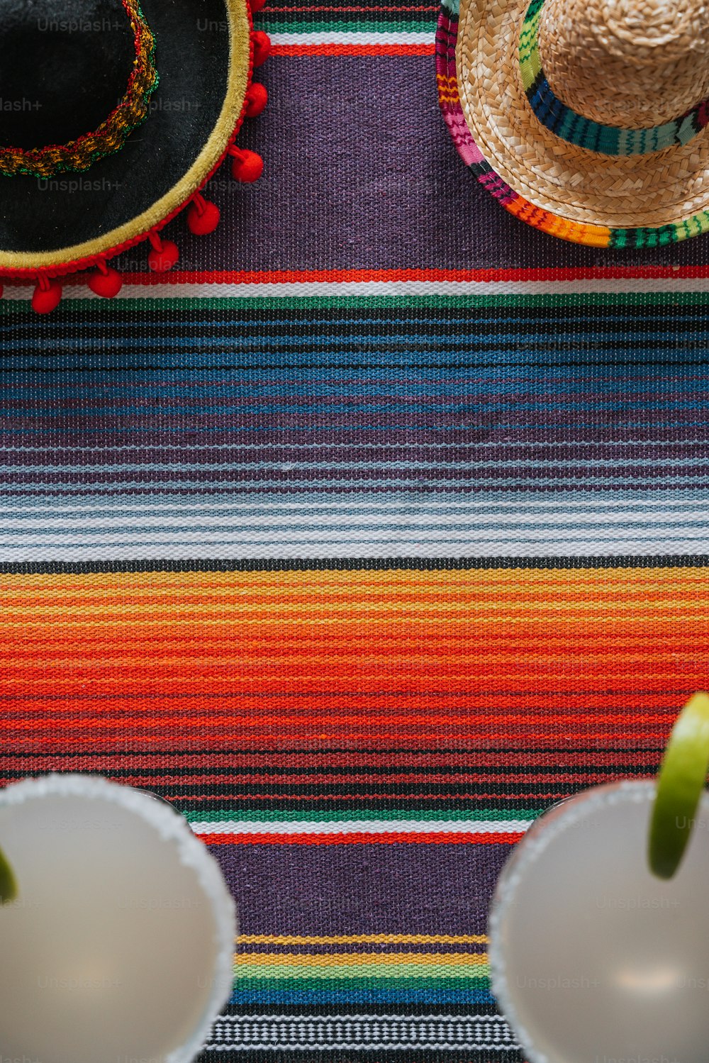 a colorful table cloth with two hats on top of it