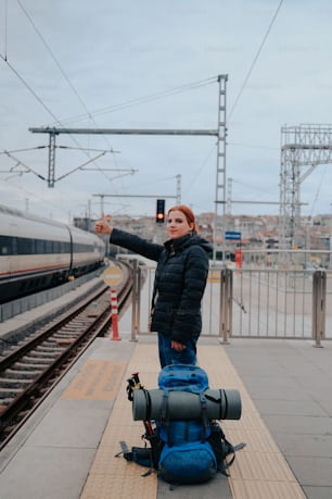 a woman standing next to a train at a train station