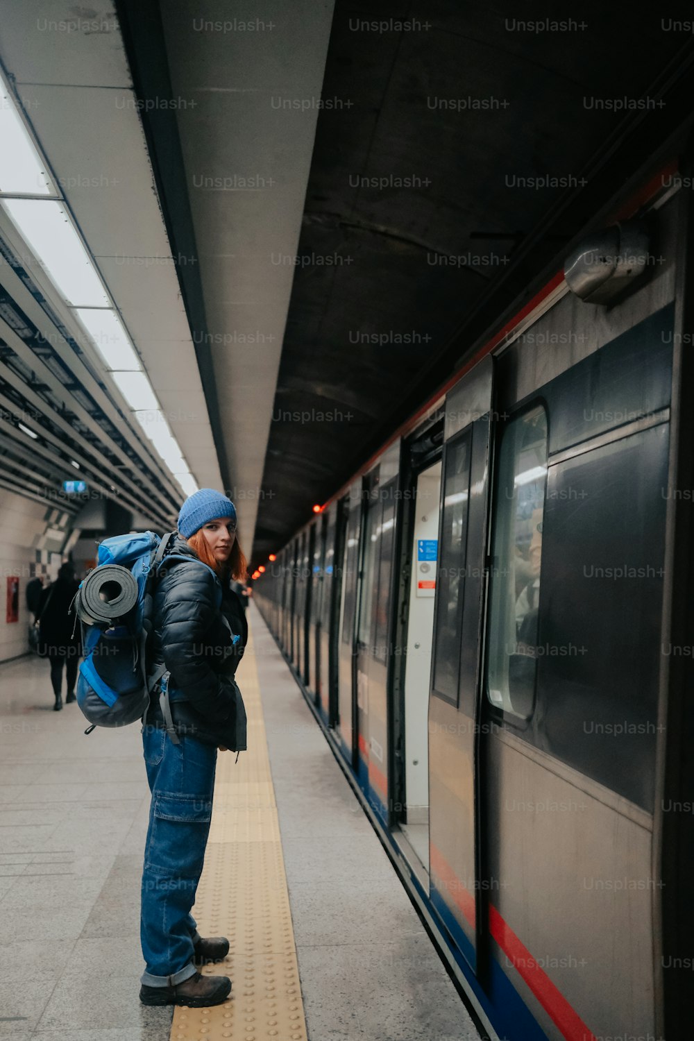 una persona in piedi su una piattaforma accanto a un treno