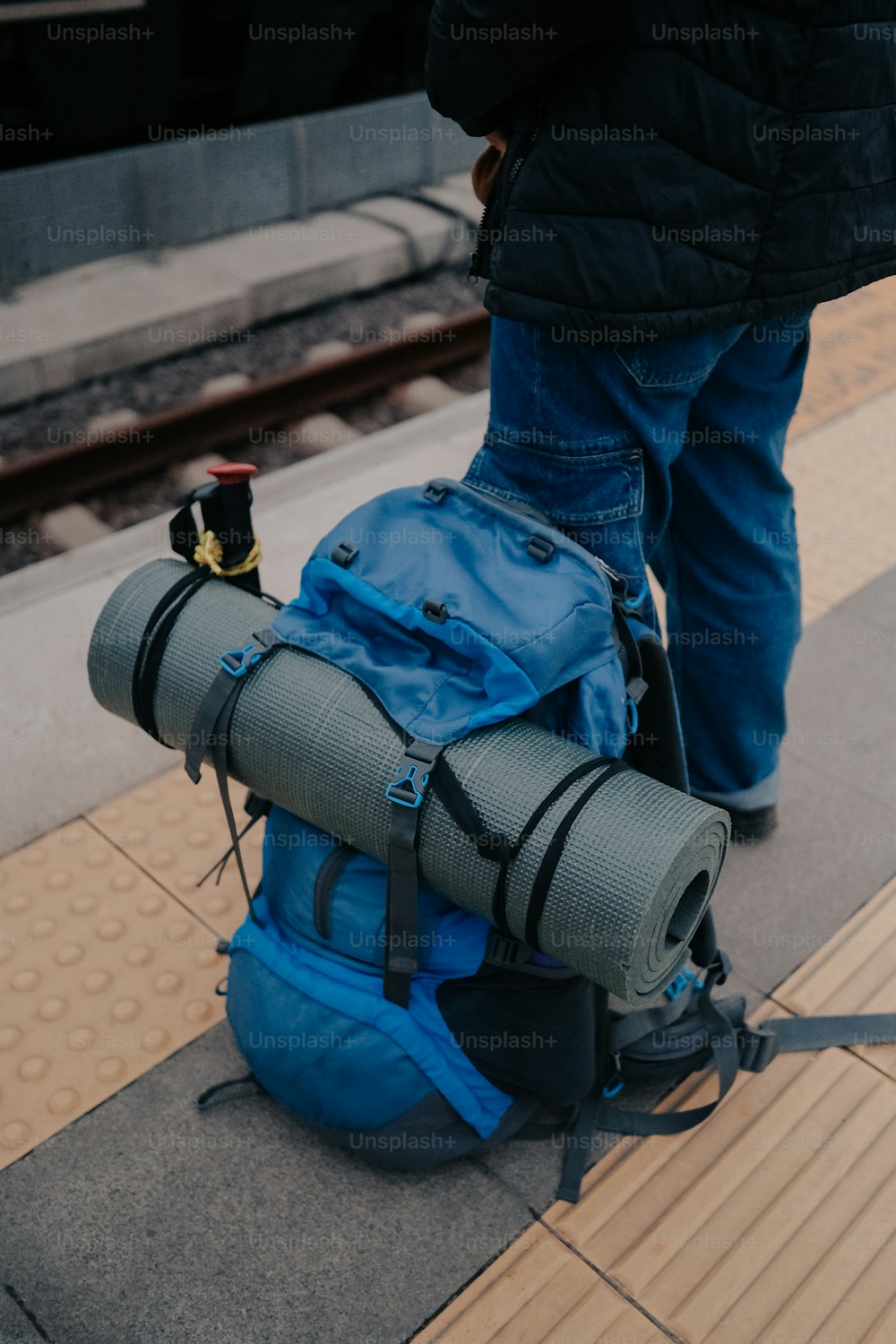 a blue backpack sitting on top of a train platform