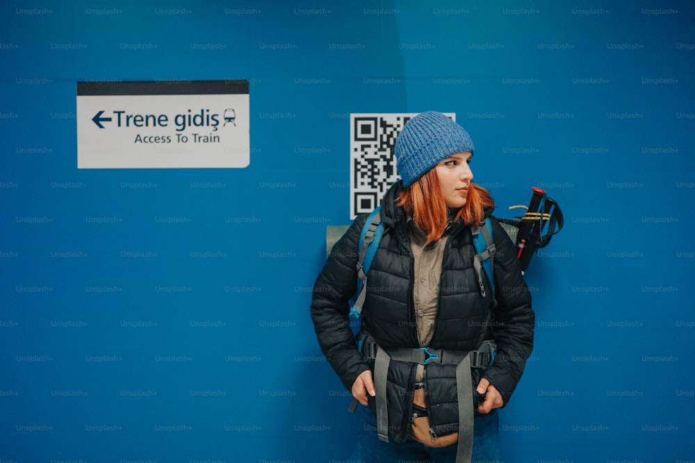 Una donna in piedi davanti a un muro blu