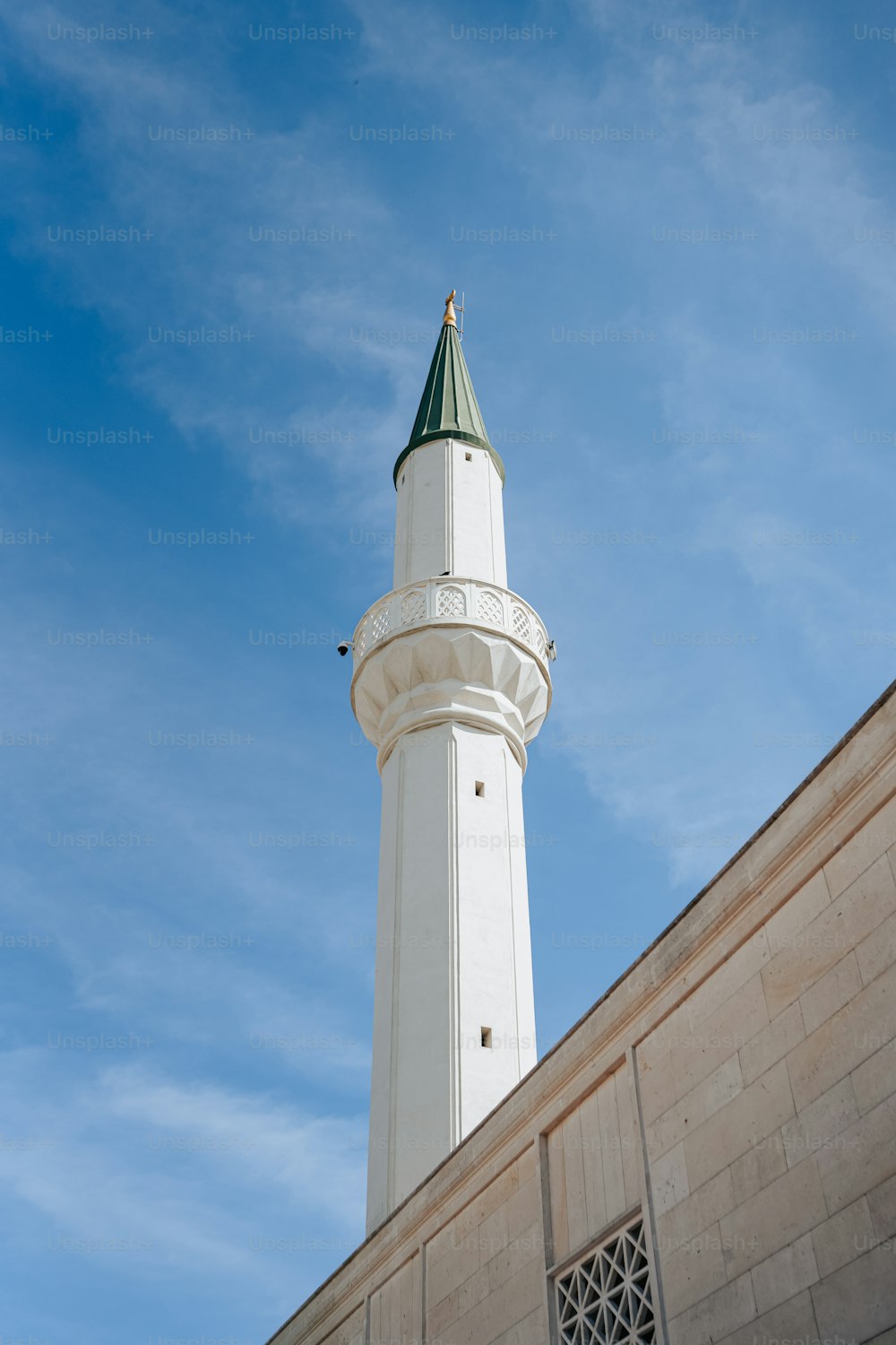 a tall white tower with a green top