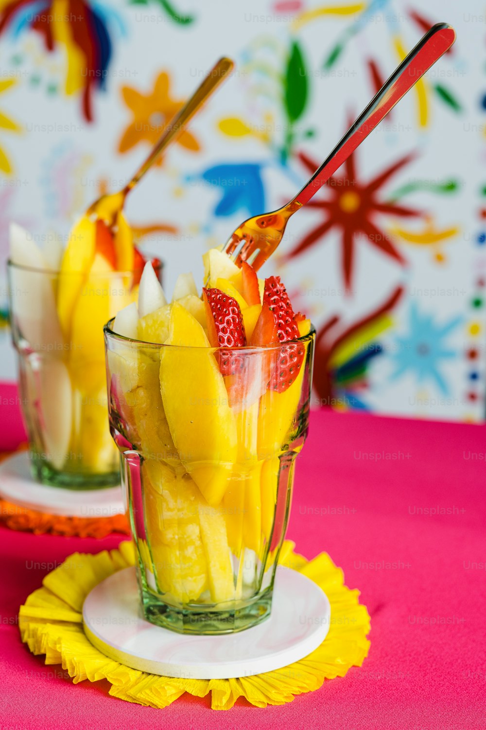 a couple of glasses filled with fruit on top of a table