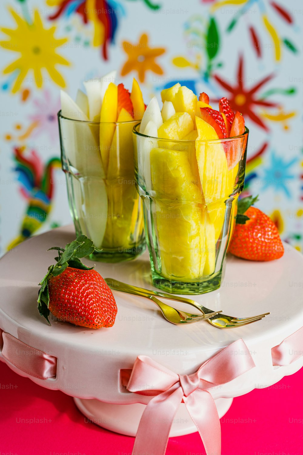 a couple of glasses filled with fruit on top of a table