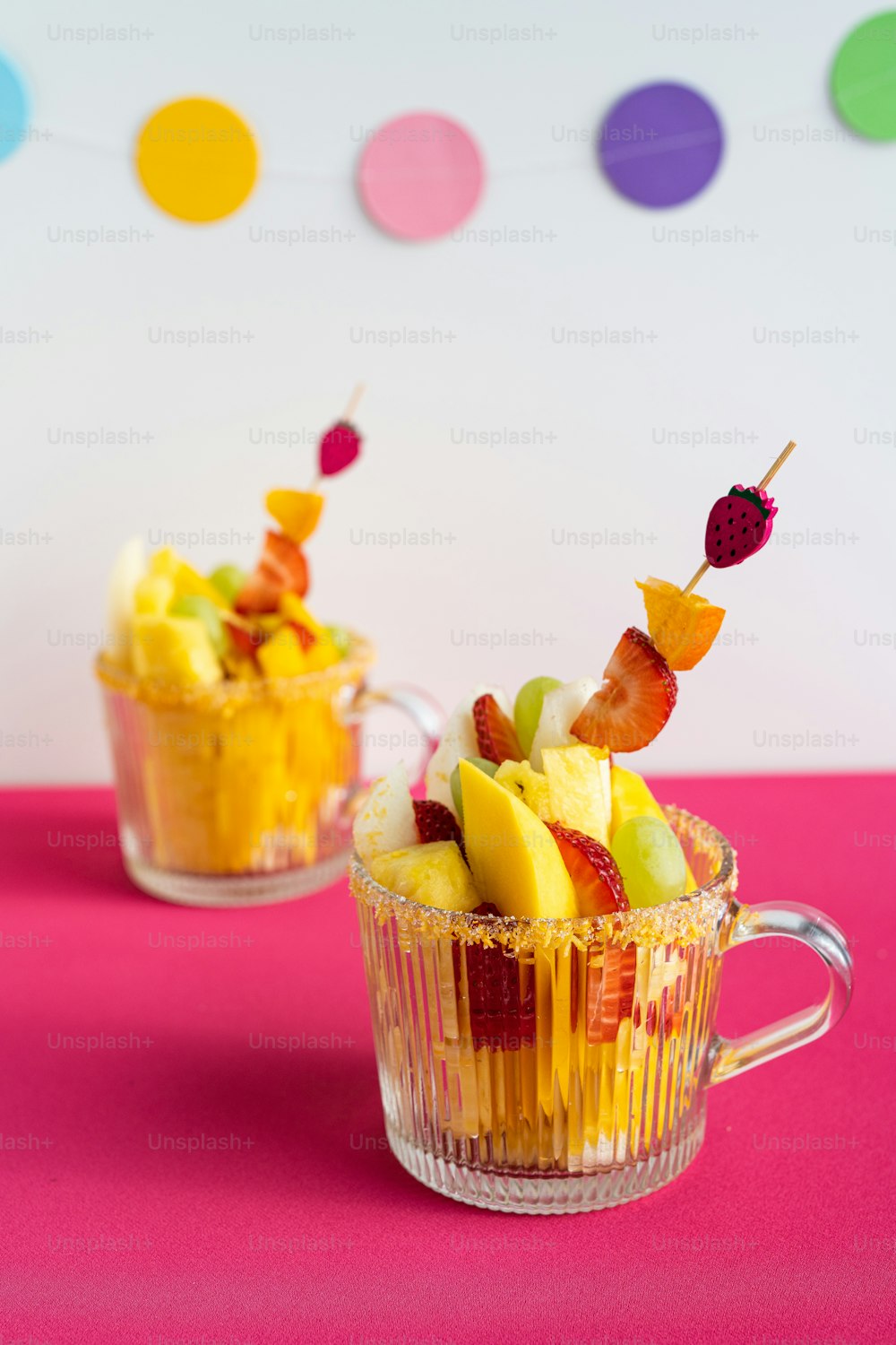 a couple of cups filled with fruit on top of a table