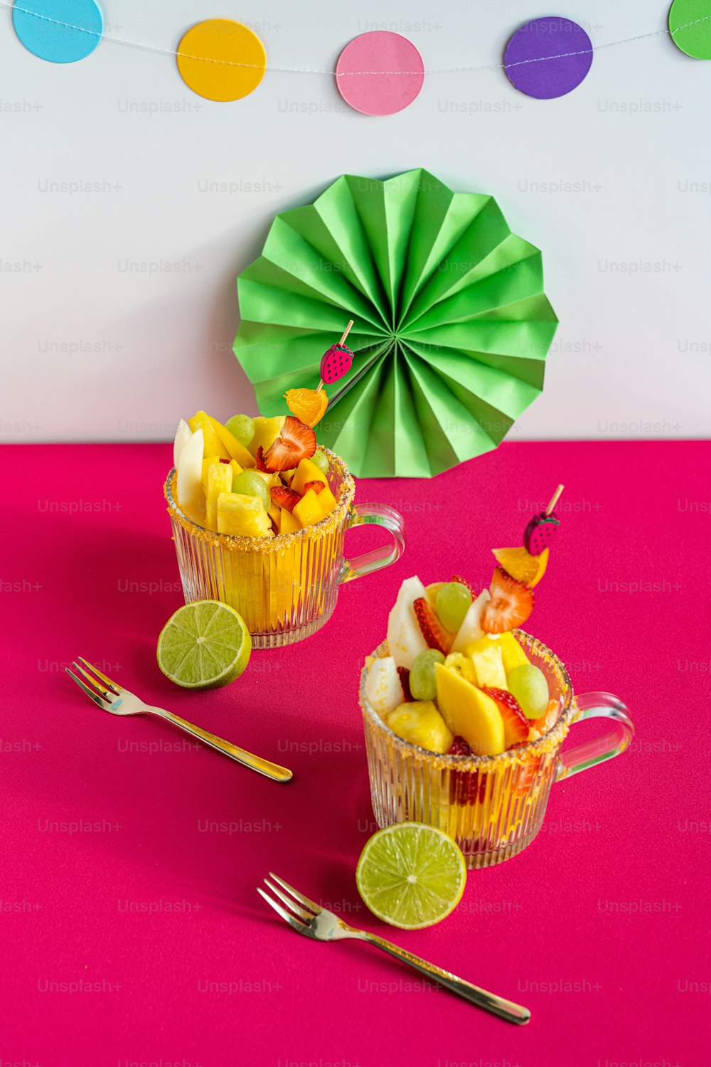 Un par de tazas llenas de fruta encima de una mesa