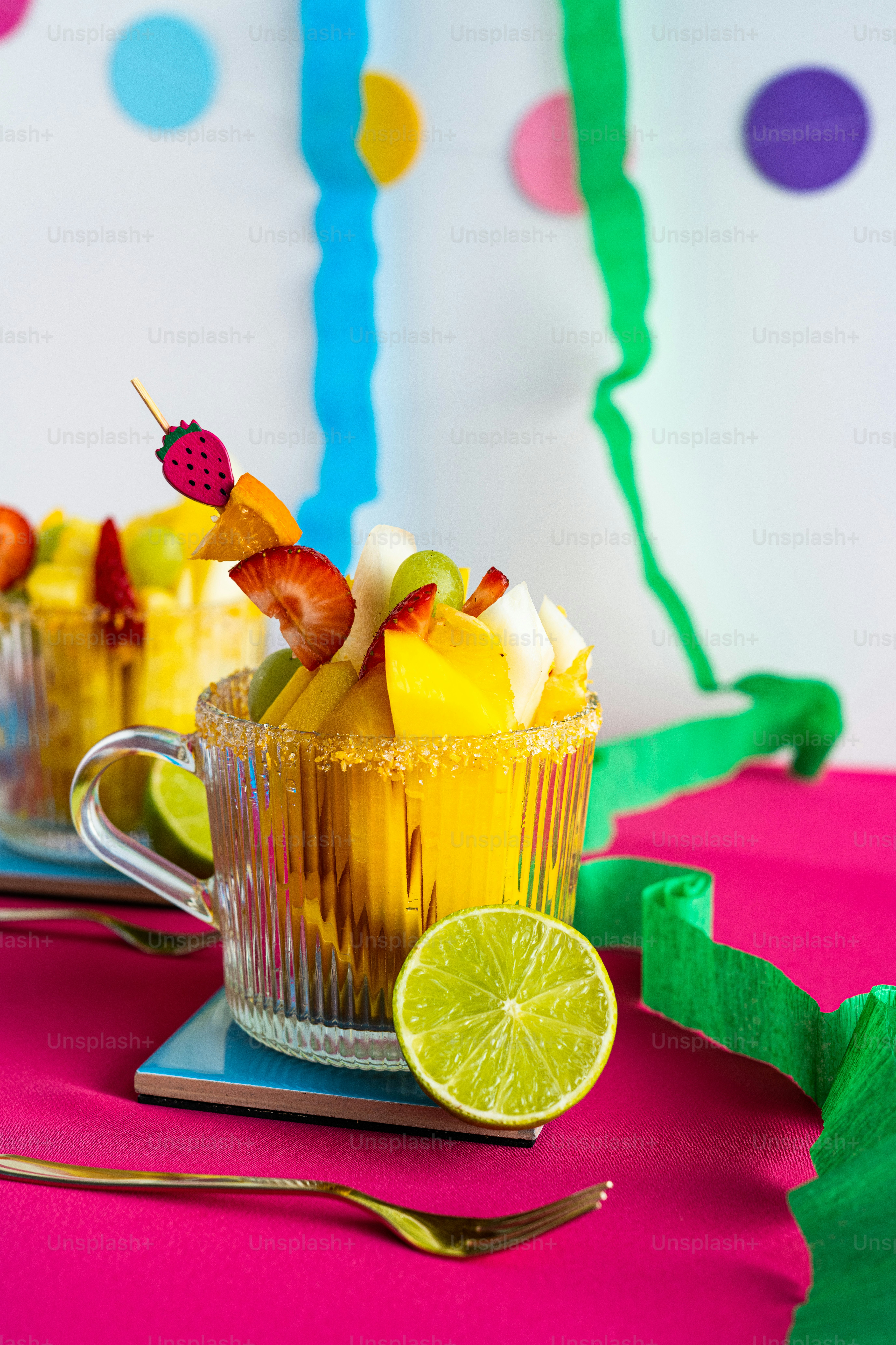 a table topped with two cups filled with fruit
