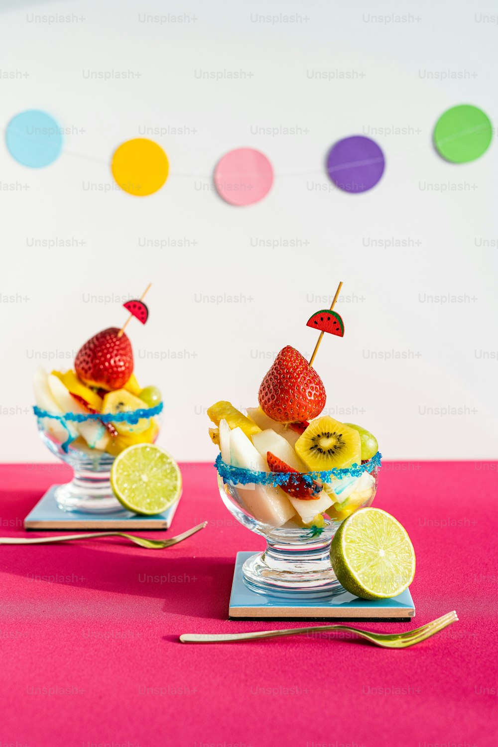 Deux plats de dessert avec des fruits et une fraise sur le dessus