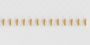 a row of gold colored beads on a white background