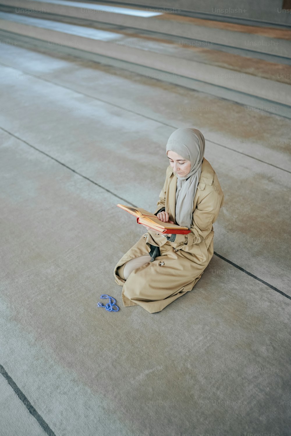 Una mujer sentada en el suelo leyendo un libro