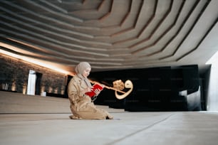 a woman sitting on the ground with a book