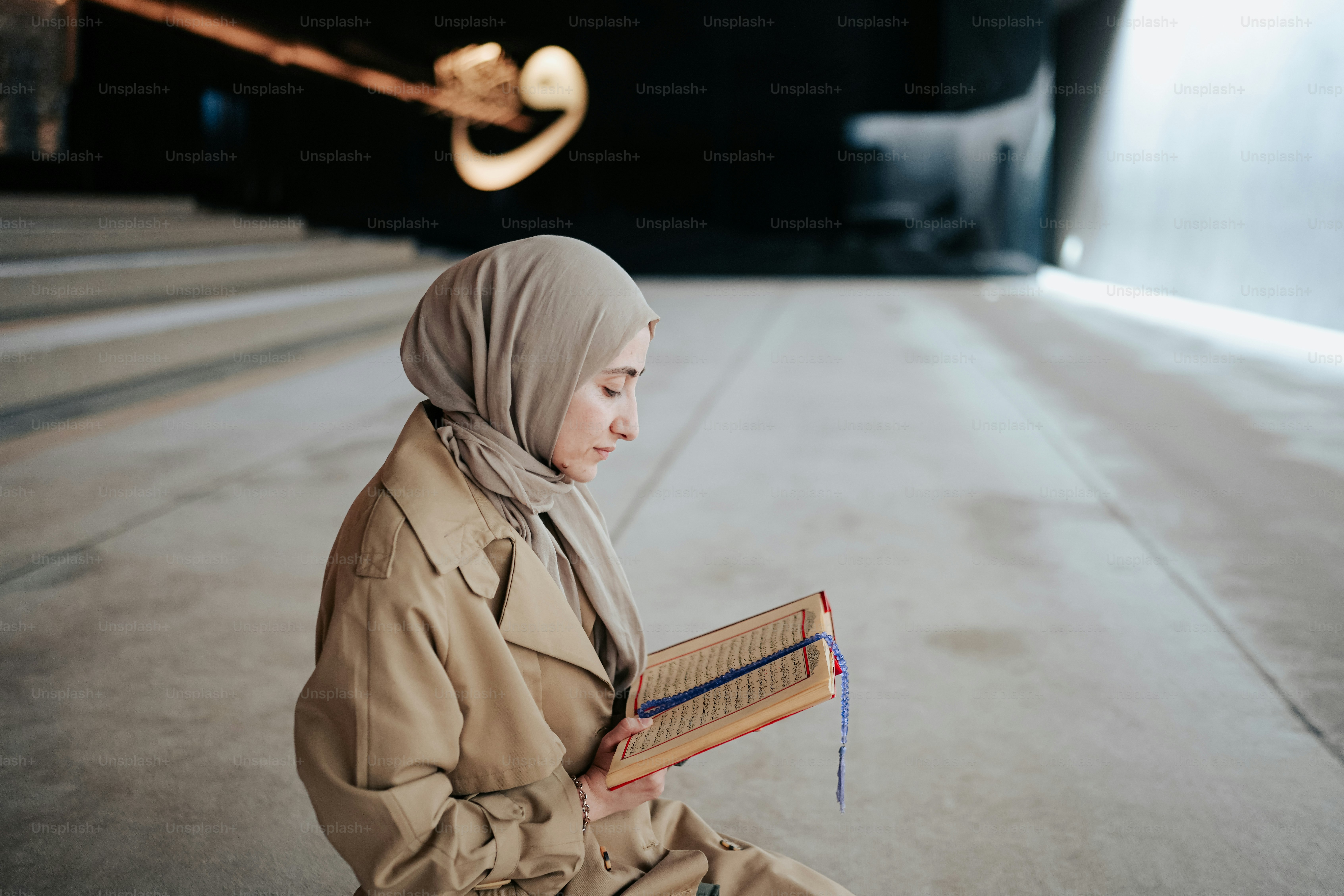 a woman in a hijab is reading a book