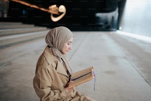 a woman in a hijab is reading a book
