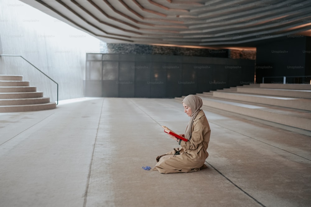 a person sitting on the ground reading a book