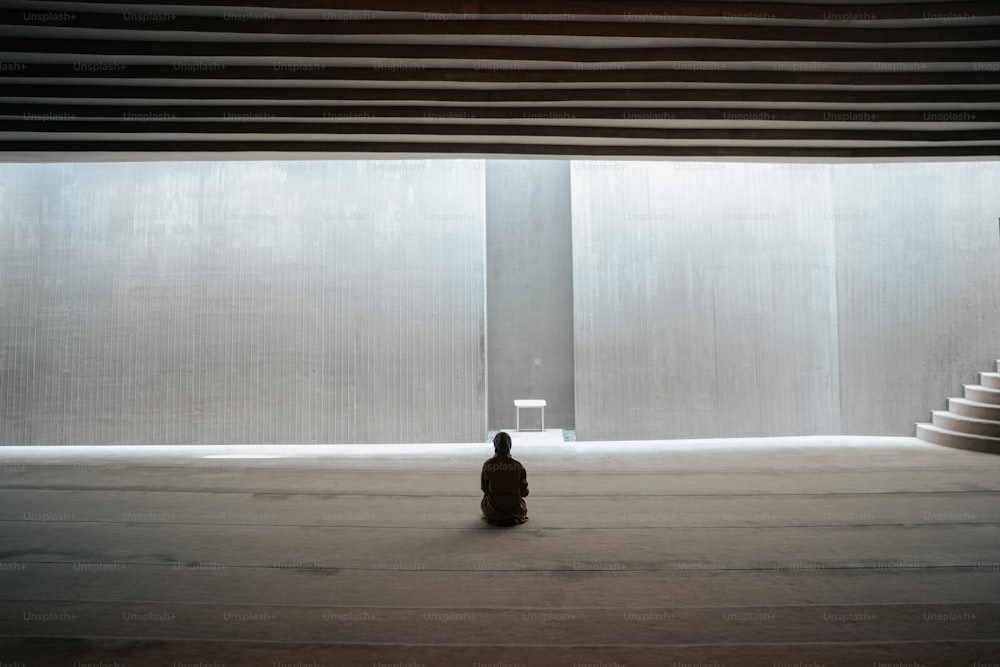 a person sitting on the floor in front of a window