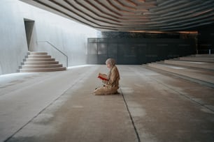 a person sitting on the ground reading a book