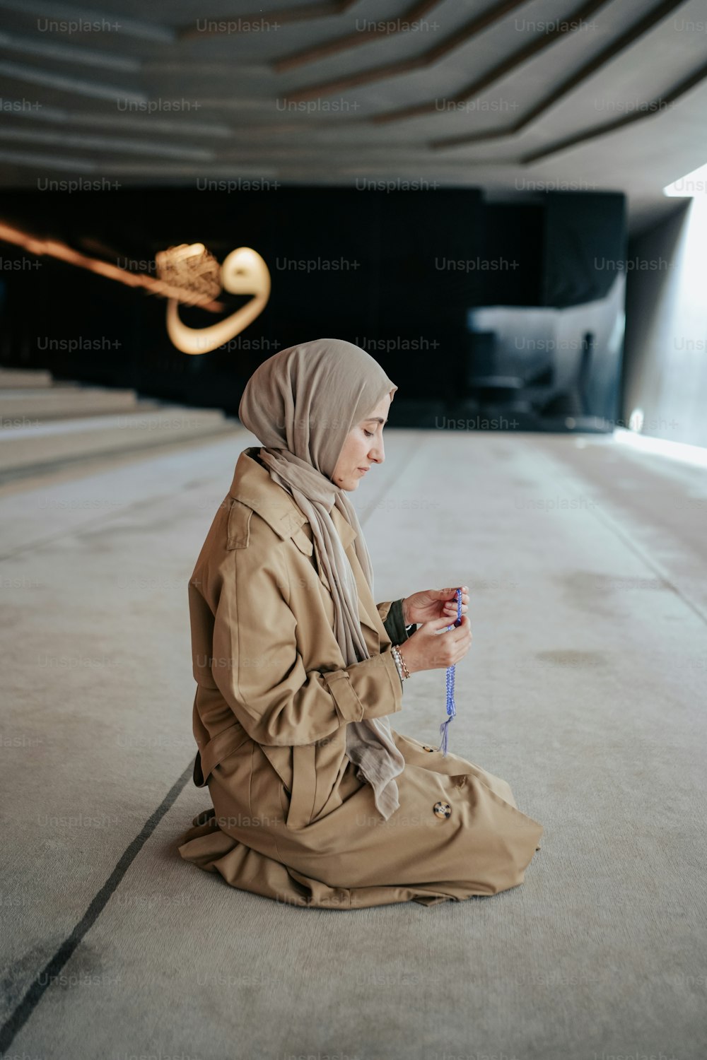 Eine Frau mit Hijab sitzt auf dem Boden