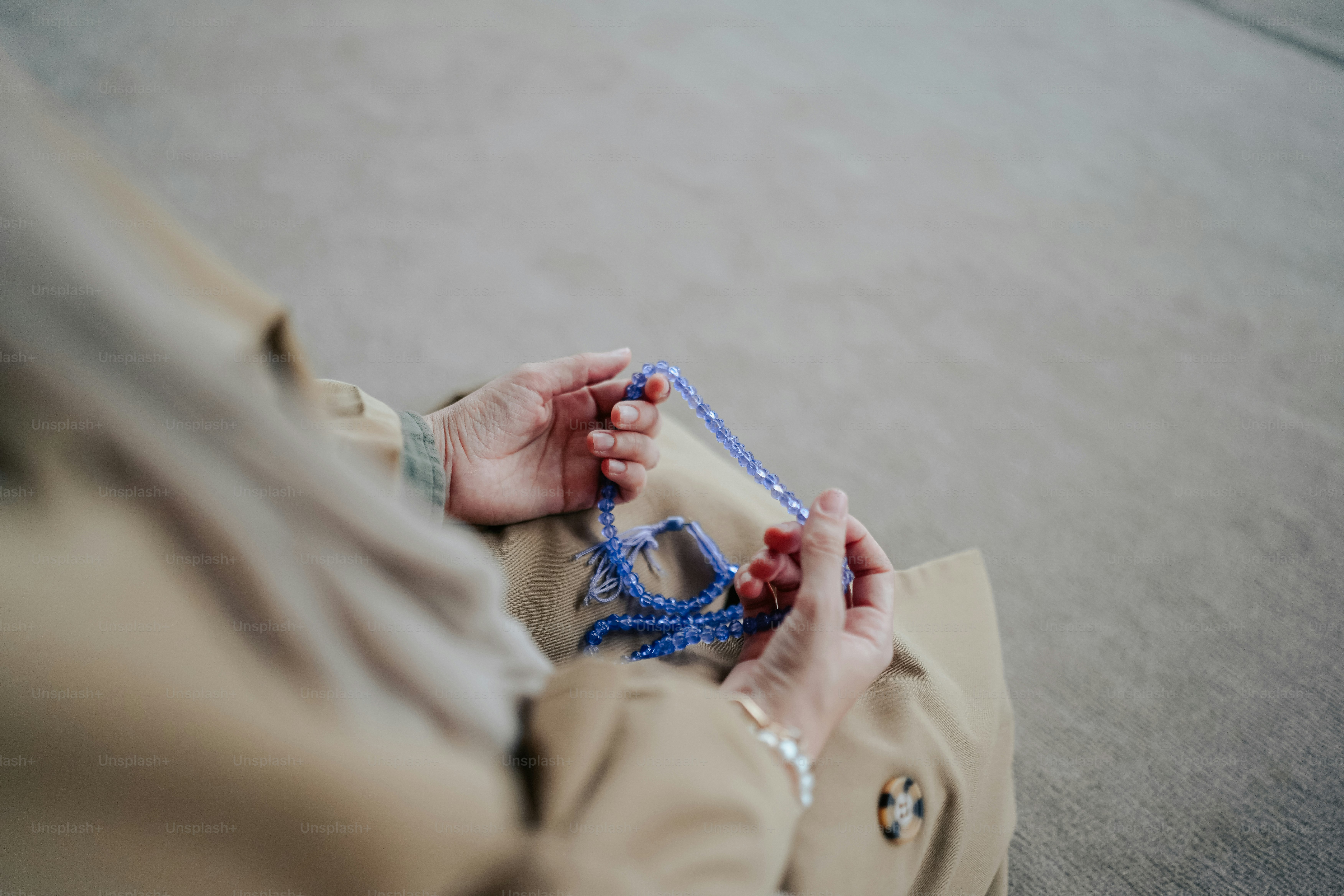 a woman sitting on the floor holding a blue string